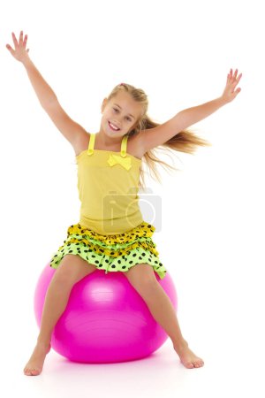 Foto de Una niña está saltando en la gran pelota de gimnasia
. - Imagen libre de derechos