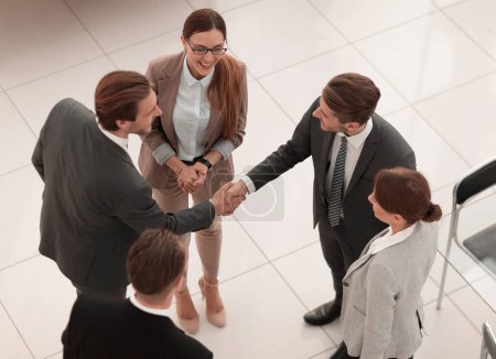 Téléchargez les photos : Top view.handshake partenaires commerciaux dans le bureau - en image libre de droit