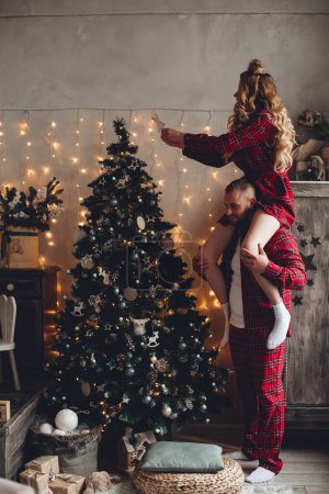 Foto de Pareja decorando árbol de Navidad en casa. - Imagen libre de derechos