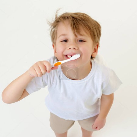 Foto de Un niño se cepilla los dientes con un cepillo de dientes.. - Imagen libre de derechos