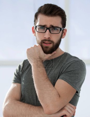Téléchargez les photos : Jeune homme moderne en t-shirt gris sur fond clair - en image libre de droit