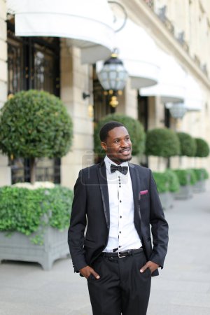 Photo for Afro american happy man wearing suit and standing near building. - Royalty Free Image