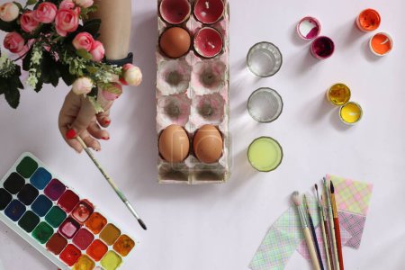 Téléchargez les photos : Peindre des œufs pour Pâques, des œufs, des peintures, des pinceaux reposent sur un fond rose - en image libre de droit