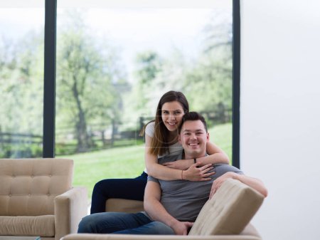 Foto de "joven pareja guapo abrazándose en el sofá
" - Imagen libre de derechos