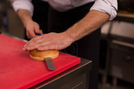 Téléchargez les photos : "chef cutting rolls for burger" - en image libre de droit