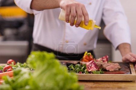 Photo for "Chef finishing steak meat plate" - Royalty Free Image