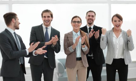 Téléchargez les photos : Une équipe d'affaires souriante applaudit leur succès - en image libre de droit