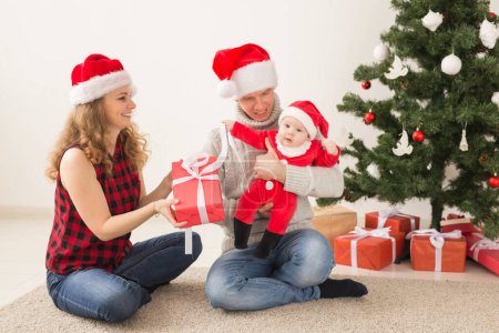Photo for Holidays, children and family concept - Happy couple with baby celebrating Christmas together at home. - Royalty Free Image