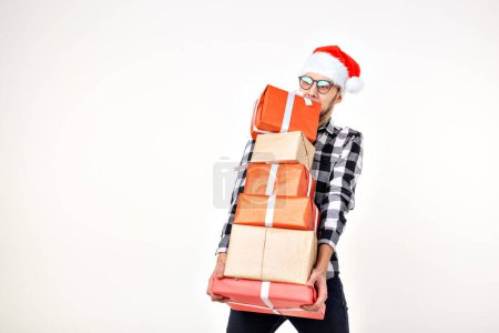 Foto de Vacaciones y presenta concepto - Hombre divertido en Navidad sombrero de Santa celebración de muchas cajas de regalo sobre fondo blanco - Imagen libre de derechos