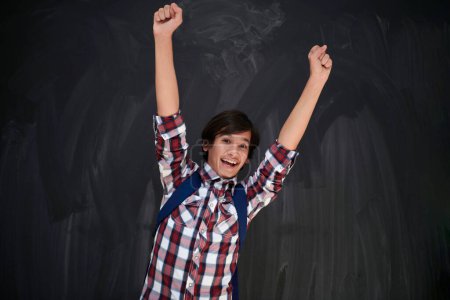 Photo for Happy arab teenager  celebrating against black chalkboard - Royalty Free Image
