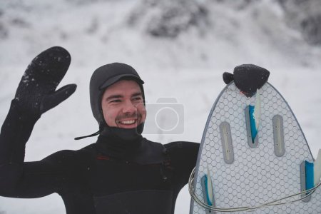 Photo for Arctic surfer portrait holding a board after surfing in Norwegian sea - Royalty Free Image