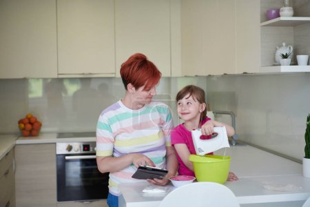 Téléchargez les photos : Mère et fille jouent et préparent la pâte dans la cuisine. - en image libre de droit