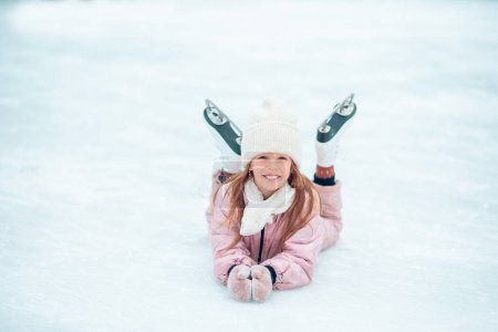 Photo for Adorable little girl skating on the ice-rink - Royalty Free Image