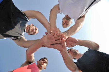 Téléchargez les photos : Joueurs de basket-ball équipe avec les mains ensemble - en image libre de droit