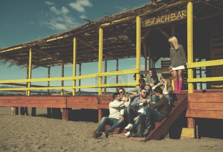Foto de Grupo de amigos divirtiéndose en el día de otoño en la playa - Imagen libre de derechos
