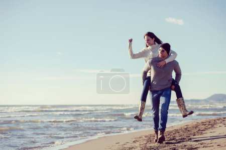 Foto de Pareja divirtiéndose en la playa en un día soleado de otoño - Imagen libre de derechos