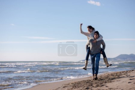 Téléchargez les photos : Couple s'amuser à la plage un jour d'automne ensoleillé - en image libre de droit