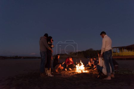 Téléchargez les photos : Amis s'amuser à la plage le jour d'automne - en image libre de droit