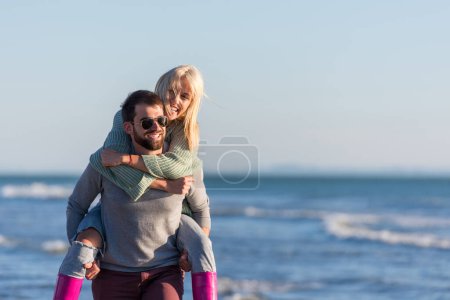 Foto de Pareja divirtiéndose en la playa en un día soleado de otoño - Imagen libre de derechos