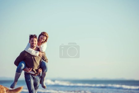 Photo for Couple having fun at beach on a sunny autumn day - Royalty Free Image