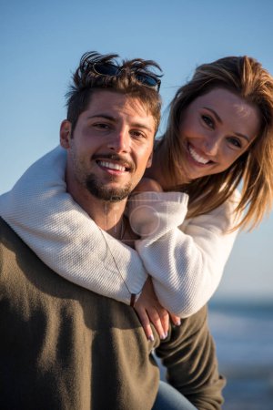 Téléchargez les photos : Couple s'amuser à la plage un jour d'automne ensoleillé - en image libre de droit