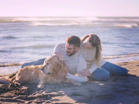 Téléchargez les photos : "Couple avec chien profitant du temps sur la plage" - en image libre de droit