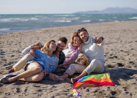 Téléchargez les photos : Groupe d'amis s'amuser sur la plage pendant la journée d'automne - en image libre de droit