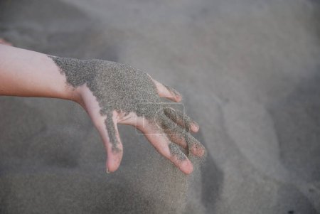 Téléchargez les photos : Sand leaking through woman hand, close up view - en image libre de droit