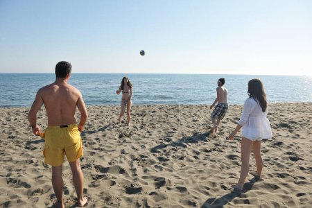 Téléchargez les photos : Groupe de jeunes ont du plaisir et jouer au beach volley - en image libre de droit