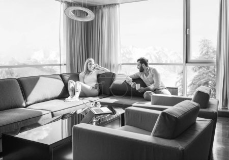 Téléchargez les photos : "couple relaxant à la maison à l'aide d'une tablette
" - en image libre de droit