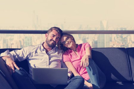 Téléchargez les photos : "couple se détendre à la maison en utilisant des ordinateurs portables
" - en image libre de droit