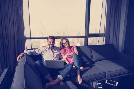 Foto de "pareja relajándose en casa usando computadoras portátiles
" - Imagen libre de derechos