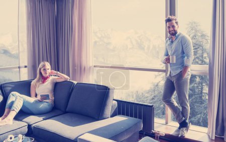 Téléchargez les photos : "couple relaxant à la maison à l'aide d'une tablette
" - en image libre de droit