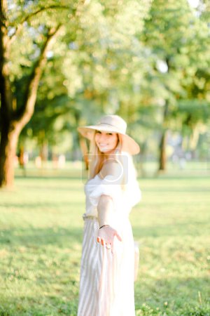 Foto de Joven linda chica con sombrero y de pie en el parque, se centran en la mano. - Imagen libre de derechos