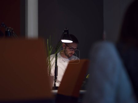 Téléchargez les photos : Homme d'affaires travaillant en utilisant un ordinateur portable dans le bureau de démarrage - en image libre de droit