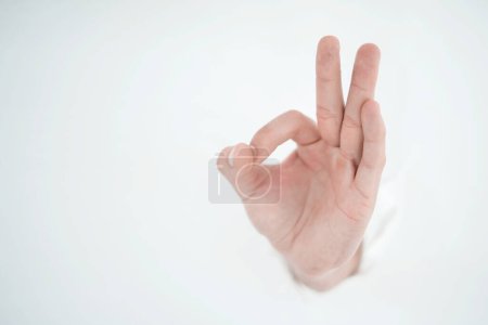 Photo for Man's hand breaking through the paper wall and pointing at yo - Royalty Free Image