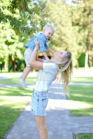 Téléchargez les photos : Jeune mère souriante jouant avec le petit fils. - en image libre de droit