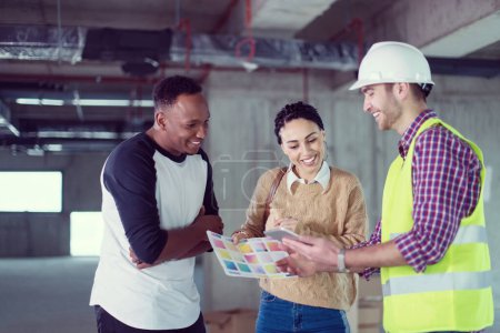 Photo for Architect showing house design plans to a young multiethnic couple - Royalty Free Image