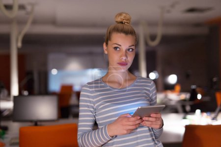 Téléchargez les photos : Femme travaillant sur tablette numérique dans le bureau de nuit - en image libre de droit