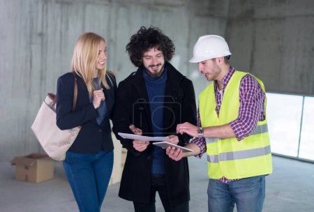 Photo for "architect showing house design plans to a young couple" - Royalty Free Image
