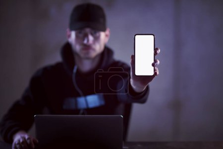 Foto de Hacker criminal usando ordenador portátil mientras trabaja en la oficina oscura - Imagen libre de derechos