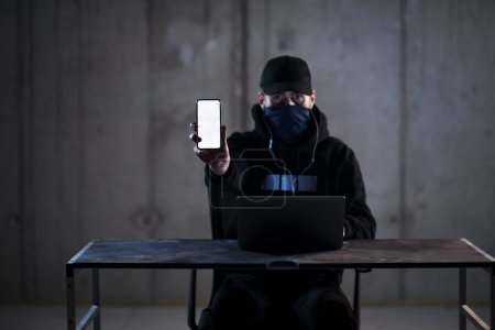 Téléchargez les photos : Pirate criminel utilisant un ordinateur portable tout en travaillant dans le bureau sombre - en image libre de droit