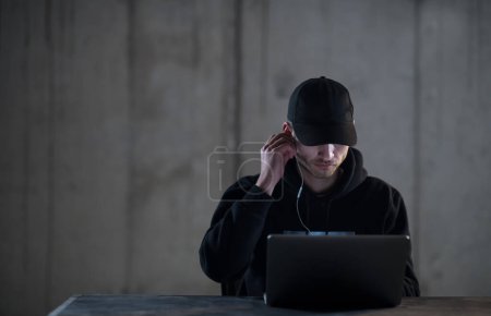 Foto de Hacker talentoso usando el ordenador portátil mientras trabaja en la oficina oscura - Imagen libre de derechos