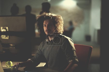 Téléchargez les photos : "homme travaillant sur ordinateur dans le bureau sombre
" - en image libre de droit
