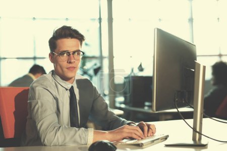Téléchargez les photos : "homme d'affaires travaillant à l'aide d'un ordinateur au bureau de démarrage
" - en image libre de droit