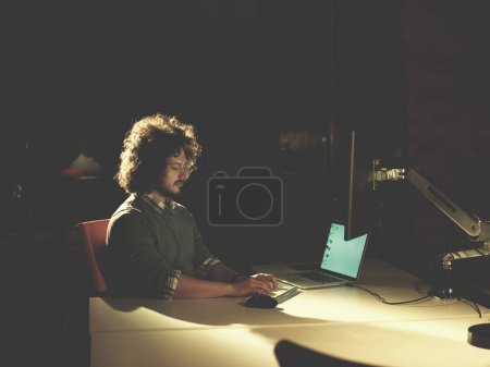 Téléchargez les photos : "homme travaillant sur ordinateur dans le bureau sombre
" - en image libre de droit