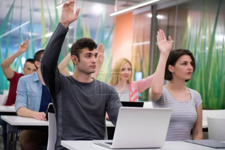Téléchargez les photos : Groupe d'étudiants lever la main vers le haut - en image libre de droit