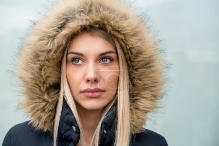 Téléchargez les photos : Portrait de jeune fille blonde portant une veste d'hiver - en image libre de droit