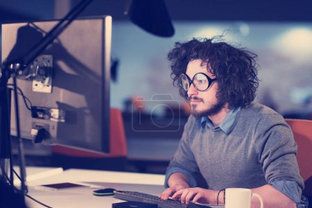 Téléchargez les photos : "homme travaillant sur ordinateur dans le bureau de démarrage sombre
" - en image libre de droit