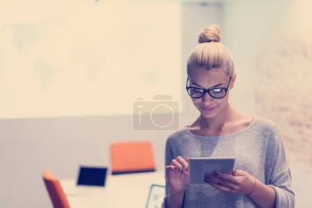 Foto de Mujer trabajando en tableta digital en la oficina nocturna - Imagen libre de derechos